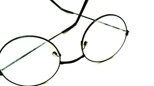 Close-up of eyeglasses on cable against white background