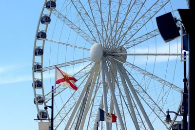 Low angle view of ferris wheel against clear blue sky