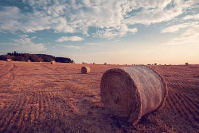 Hay bales on field against sky