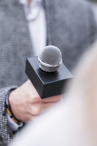 Midsection of man holding microphone