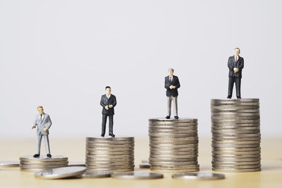 Stack of people with arms raised against gray background