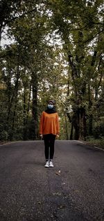 Rear view of man walking on road