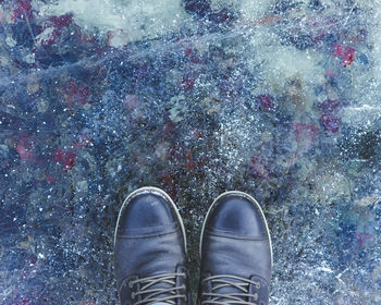 Close-up of shoes on frozen lake