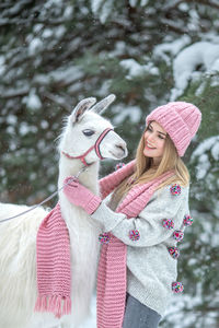 Portrait of young woman with horse standing on field