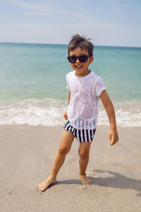 Portrait of young woman standing at beach