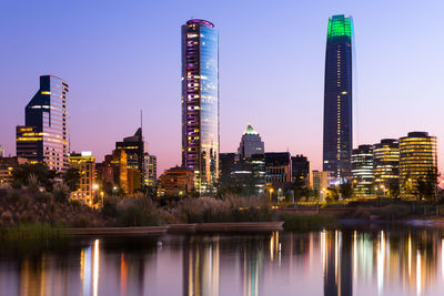 Illuminated skyscrapers against clear sky at night