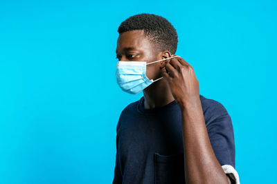 Portrait of young man against blue background