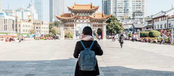 Rear view of woman standing against temple