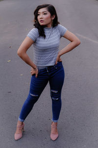 Portrait of a young woman standing on road