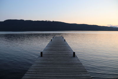 Pier over lake against clear sky