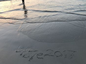 Close-up of text on sand at beach