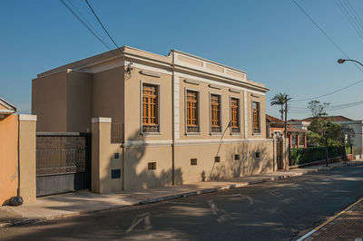  old townhouse with iron gate in an empty street on a sunny day at sao manuel, brazil.