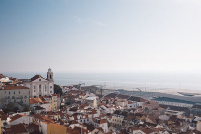 High angle view of townscape by sea against sky