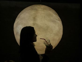 Low angle view of woman standing against black background