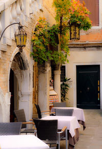 Empty chairs and table against building