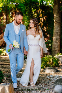 Couple holding hands against plants