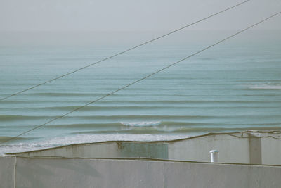 Close-up of wall by sea against sky