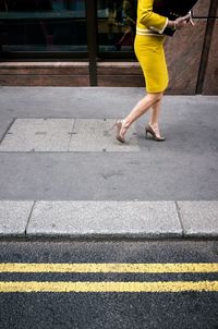 Low section of woman standing on street