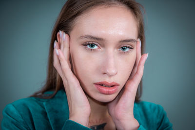 Portrait of beautiful young woman against gray background