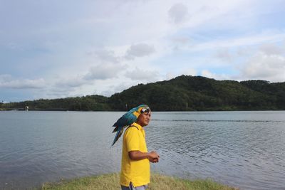 Man standing in lake against sky