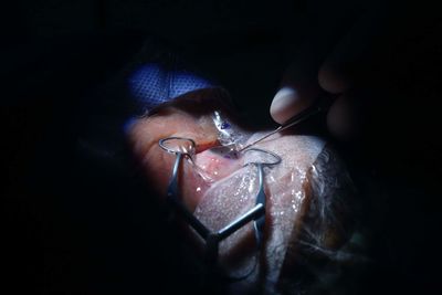 High angle view of hand holding illuminated lighting equipment in darkroom