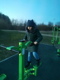 Girl playing on outdoor play equipment