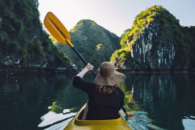 Rear view of woman on boat in lake