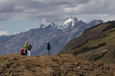 People on mountains against sky