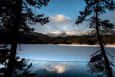 Scenic view of lake and mountains against sky during winter