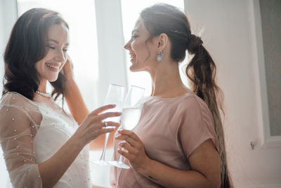 Bridesmaid and bride holding champagne flute