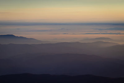 Scenic view of silhouette mountains against sky during sunset