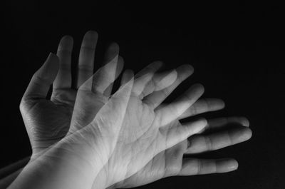 Double exposure of hands over black background