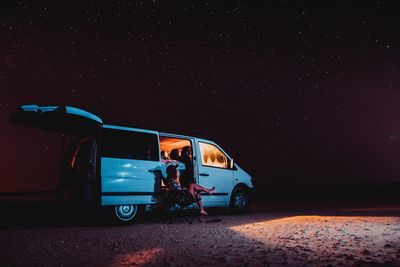 People in bus against sky at night