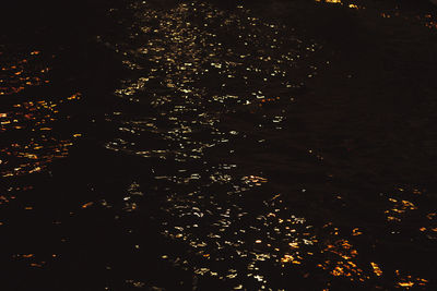 High angle view of illuminated lake against sky at night