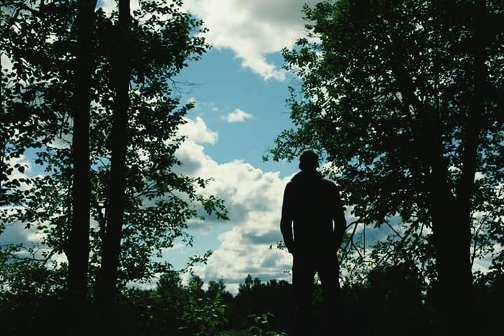 REAR VIEW OF A SILHOUETTE MAN ON LANDSCAPE