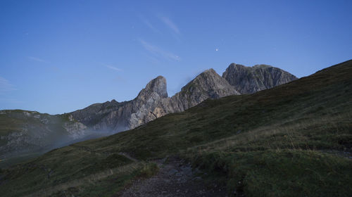 Scenic view of mountains against clear blue sky