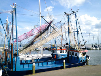 Boats moored at dock against sky