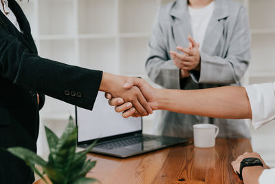 Midsection of businessmen shaking hands