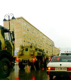 Cars on road in city against sky