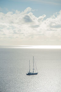 Sailboat sailing on sea against sky