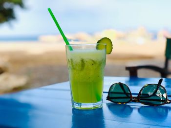 Close-up of drink on table against swimming pool