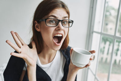 Portrait of young woman with coffee cup