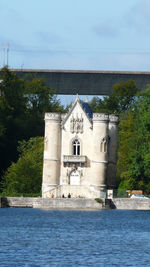 Church by river against sky