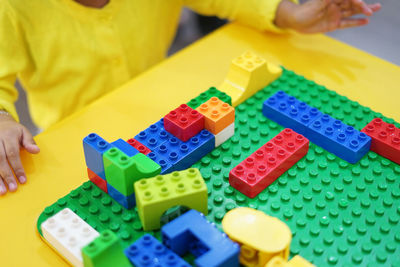 Midsection of girl playing with toy blocks