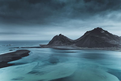 Scenic view of snowcapped mountains by sea against sky