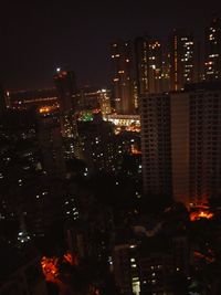 Illuminated cityscape against sky at night