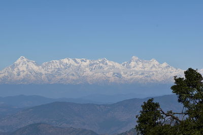 Scenic view of snowcapped mountains against clear blue sky