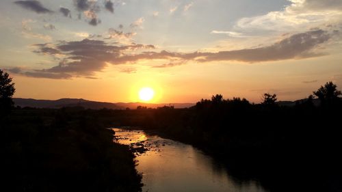 Scenic view of river against sky during sunset