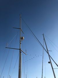 Low angle view of sailboat against clear blue sky