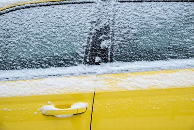 Close-up of yellow car in snow